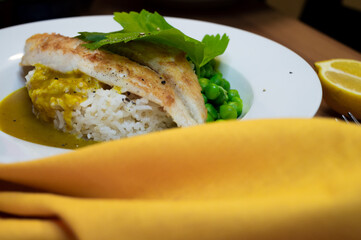 grilled fish fillet on rice with yellow napkin on wooden table