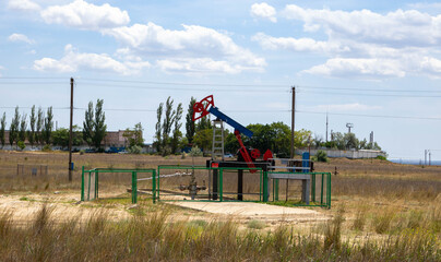 Fototapeta na wymiar Small pump. Oil pump . Equipment for the oil industry. Oil rocking chair in the open air.