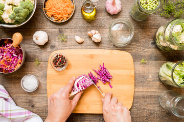 Hands cut cabbage for canning and other canning vegetables. Food preservation and conservation concept.