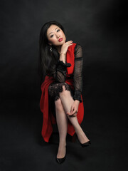 Asian woman model in long dress sitting