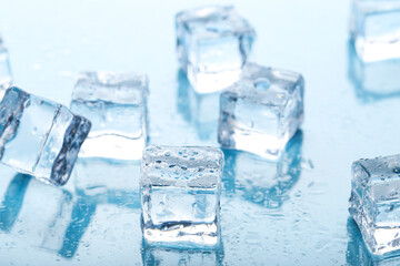 Ice cubes with water drops on blue background