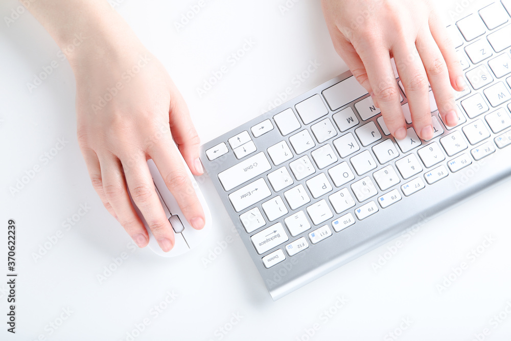 Poster female hands typing on computer keyboard and holding mouse on white background
