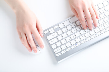 Fototapeta na wymiar Female hands typing on computer keyboard and holding mouse on white background