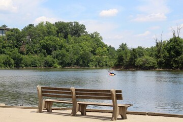 Fototapeta premium The old wood bench on the shore at the lake in the park.