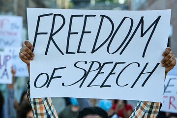 Close-up of protester holding freedom of speech banner on public demonstrations.