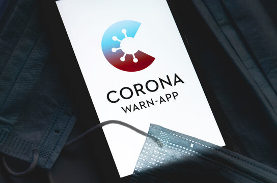 Corona Warn App logo on the screen smartphone with masks in the dark closeup. Corona-Warn-App is a COVID-19 contact tracing application. Moscow, Russia - July 12, 2020