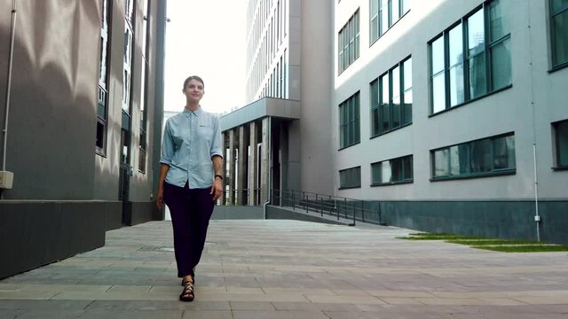 Businesswoman in office suit walking near the business center. Successful female office worker