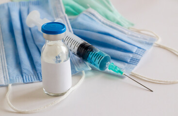 Mini medicine glass bottle and injector with medical masks on white background.Conceptual image of medical sector