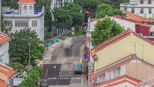Aerial view of art deco shophouses with red roofs along Neil road in Chinatown area timelapse. Traffic on the street with intersection