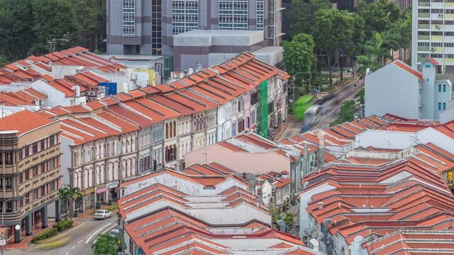 Aerial view of art deco shophouses with red roofs along Neil road in Chinatown area timelapse. Traffic on the street with intersection