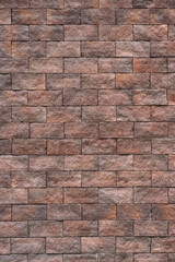 Full-screen texture of the building wall facing with brown artificial stone slabs
