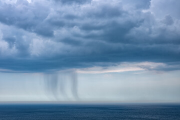 Small rain over the sea from a dark cloud