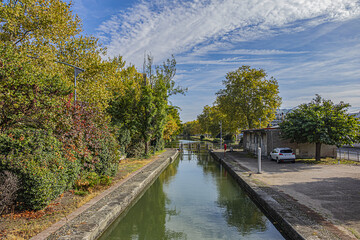 Beautiful autumn views of Canal du Midi (in XVII century - Royal Canal in Languedoc) in Toulouse and trees reflection in water. Toulouse, Haute-Garonne, France.