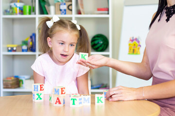 developmental and speech therapy classes with a child-girl. Speech therapy exercises and games with letters. dice game