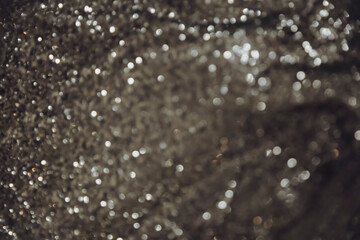 Close up picture of dark gold defocused shimmering glitter fabric. Gold shade with shiny macro blur effect, as greeting card for holiday. Winter Christmas card with sparkle background.