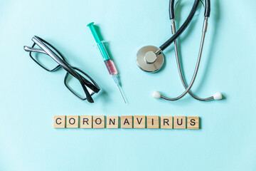 Text phrase Coronavirus syringe eyeglasses and stethoscope on blue pastel background. Novel coronavirus 2019-nCoV MERS-Cov covid-19 middle East respiratory syndrome coronavirus virus vaccine concept.