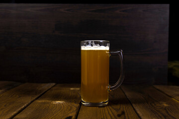 a glass of cold thick unfiltered beer on a wooden table