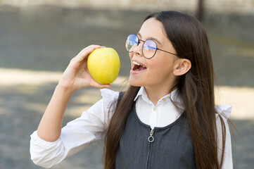 Healthy dose of vitamin C. Happy kid eat apple outdoors. School snack. Vitamin nutrition. Health...