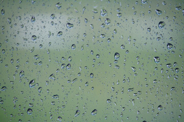 Close-up of glass with raindrops on natural background, drops of water on car glass, selective focus