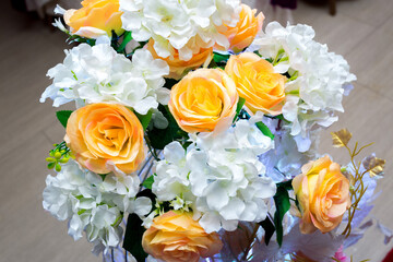 White and yellow artificial paper flowers vase. wedding decoration. Plastic colorful decorated rose flower.