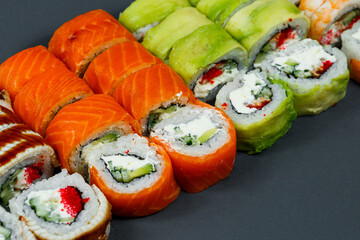 Sushi assorted. Sushi roll with avocado, cucumber. Sushi roll with salmon and caviar. Sushi roll with tuna and caviar. On a light background. Japanese food. View from above