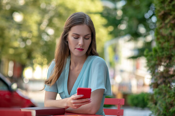 Upset female sitting in cafe, checking phone, biting lips