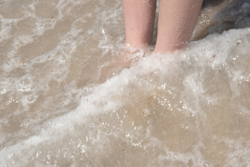 Fototapeta premium Feet in waves at the beach