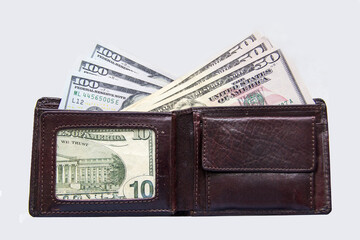 Wallet with dollars stands on a white background. Money dollars from different sides of a leather brown wallet.