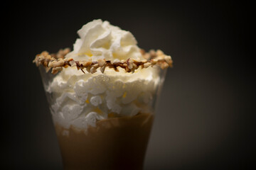 Tasty Italian hot chocolate in a big glass. Is a tasty chocolate with handmade whipped crema on top, is a n Italian ice cream with chocolate in a large fancy glass. All with a black background