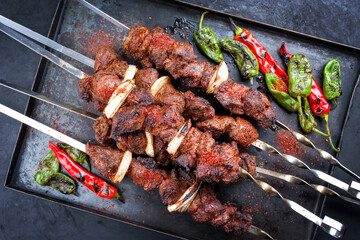 Traditioneller russischer Lamm Schaschlik Grillspieß  mit Lammfleisch, Chili und Zwiebel als als Draufsicht auf einem Metal Tablett