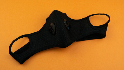 Protective non medical face mask rotation, New Normal social concept, on orange background.  Wearing prevention and protection from coronavirus COVID-19 virus and urban air pollution.