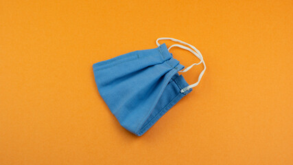 Protective non medical face mask rotation, New Normal social concept, on orange background. ...