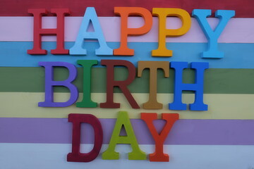 Happy Birthday composed with multicolored wooden letters over multicolored wooden board