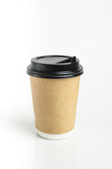 Eco friendly paper craft cup for coffee with black lid on the white background. Zero waste, plastic free concept. Sustainable lifestyle. Front view.