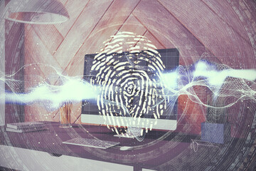 Personal Computer on table with abstract glowing finger print interface.