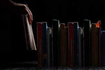detail of a hand holding an antique book from a library
