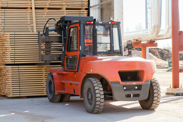 Fototapeta na wymiar workers load boards with an industrial loader at a sawmill