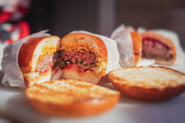 Process of cooking classic burgers with beef on open-air, view of chef hands in  gloves with variety of fillings and ingredients on wooden desk and stove