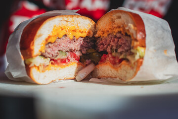 Process of cooking classic burgers with beef on open-air, view of chef hands in  gloves with variety of fillings and ingredients on wooden desk and stove
