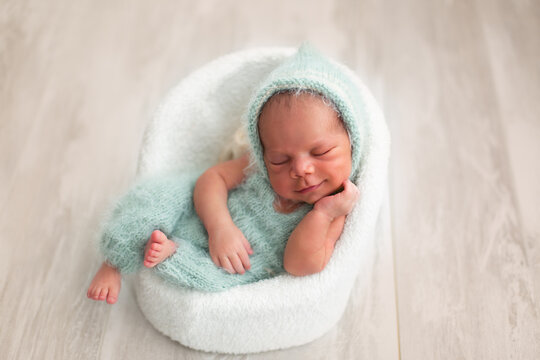 a black newborn baby smiles. the first photo session of a newborn. newborn in a chair