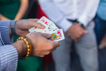 Magician showing card tricks focus in front of guests on party event wedding celebration, juggler performing show