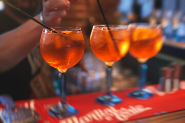 Row line of red colored negroni and spritz aperitif alcohol cocktails on a party of alcohol setting...