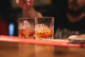 Row line of red colored negroni and spritz aperitif alcohol cocktails on a party of alcohol setting on catering banquet table, vodka, and others on decorated catering table event with bartender