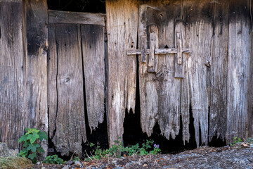 partially burnt-down wooden door with a jagged bottom and a wooden lock