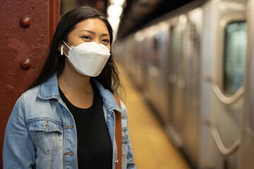 Young Asian woman wearing a mask at subway platform