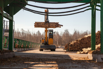 Industrial loader transports logs at a sawmill