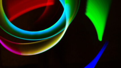 Geometric circles, spirals, circles and arbitrary lines drawn by a multi-colored lamp in the dynamics of movement at a long exposure.
