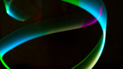 Geometric circles, spirals, circles and arbitrary lines drawn by a multi-colored lamp in the dynamics of movement at a long exposure.