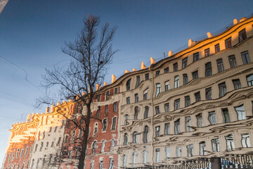 river Reflection of vintage houses and trees without leaves