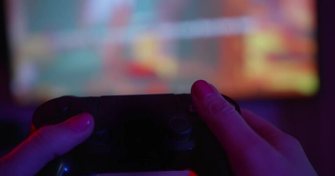Young female hand with gamepad playing video games